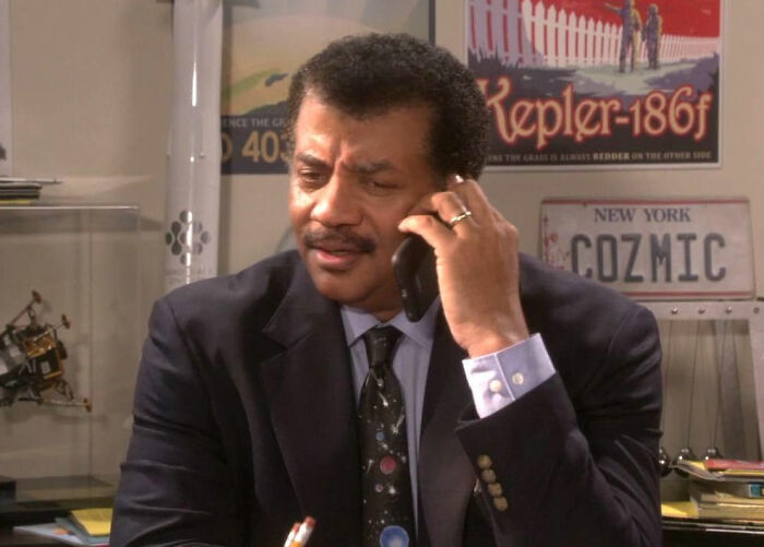 Man in a suit on phone in an office setting, illustrating experiences of movie set workers with diva stars.