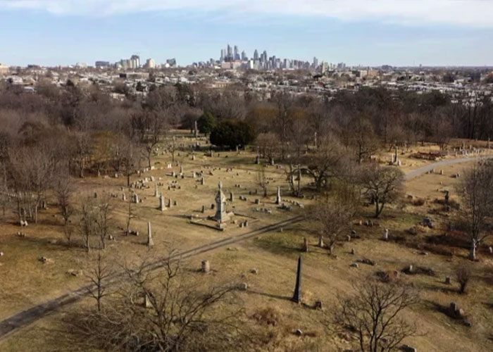 Aerial view of a chilling house near a city skyline with barren trees and old gravestones, hinting at a horrifying discovery. Aerial view of a chilling house near a city skyline with barren trees and old gravestones, hinting at a horrifying discovery.