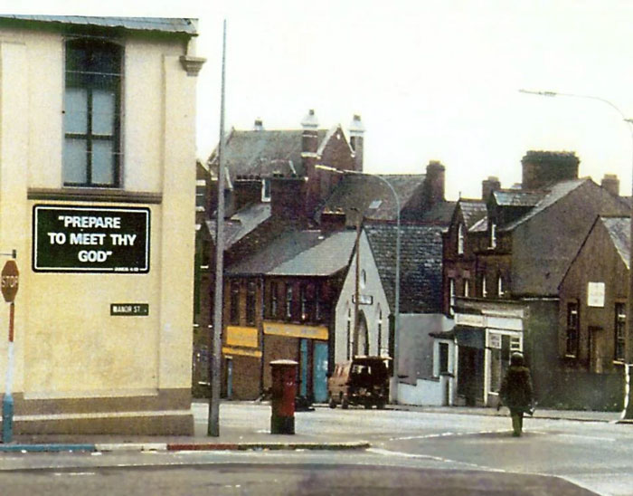 Street view in a local neighborhood with a sign that says prepare to meet thy God, a photo from a country that hits hard.