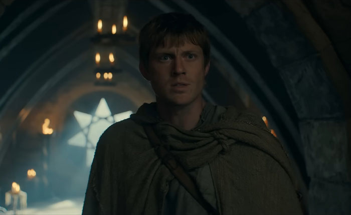 A knight in medieval cloak standing inside a dimly lit stone hall, related to Rotten Tomatoes rating discussions.