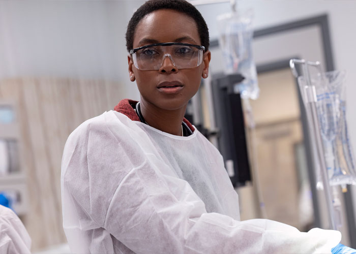 Dr. Heather Collins in medical protective gear, in a hospital setting, representing character fate in The Pitt season 2.