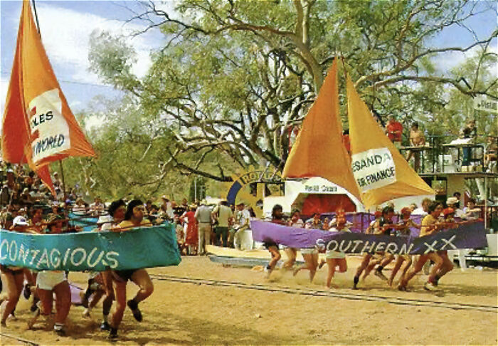 Participants race wearing colorful sail costumes during a strange tradition from around the world event outdoors.