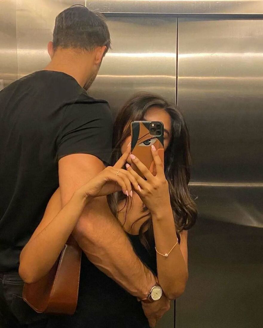 Couple taking a selfie in an elevator, embracing each other and showing cute and fun questions to ask your partner vibes.