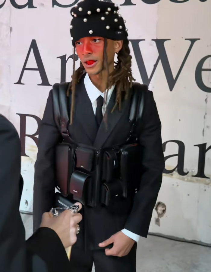 Fashion influencer wearing a pearl-studded hat and multiple black pouches in a bold streetwear look inspired by Black Brooklyn Beckham style Fashion influencer wearing a pearl-studded hat and multiple black pouches in a bold streetwear look inspired by Black Brooklyn Beckham style