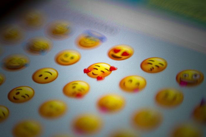 Close-up of phone screen showing various emojis, highlighting the role of the phone in revealing signs of cheating.