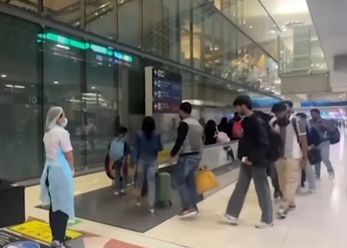 Passengers wearing masks at airport amid incurable virus outbreak leading to COVID-style restrictions and doctor issuing warnings.