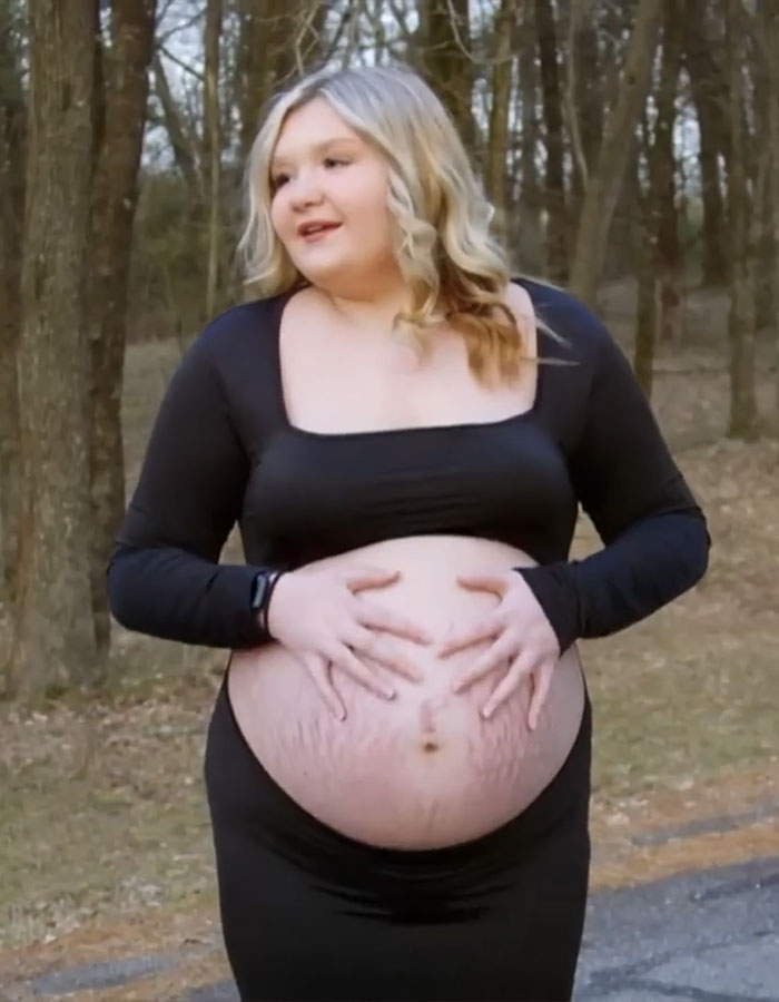Pregnant 15-year-old girl holding her belly outdoors, related to family impact story on young pregnancy.