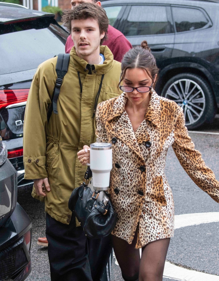 Cruz Beckham and his mom lookalike girlfriend walking outdoors, sparking buzz about how old she is.