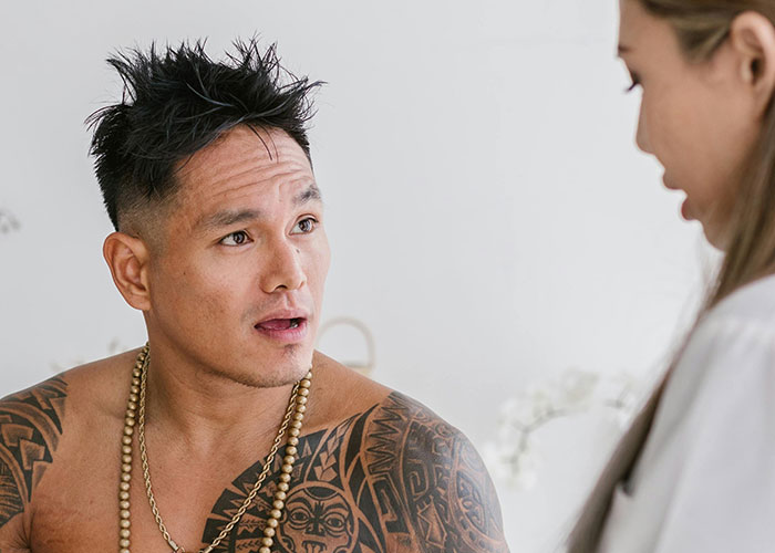 A tattooed man with a concerned expression talks to a female medical professional about worst things medical professionals said.