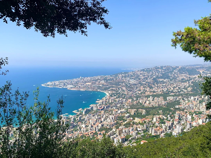Panoramic coastal city with dense apartment blocks and blue sea, illustrative image for Most Stressful Countries report.