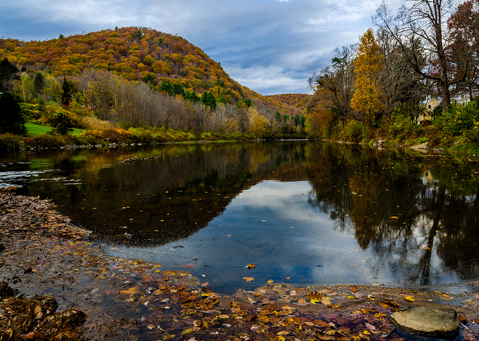 Calm river reflecting autumn trees and hills in one of the most haunted places in America with dark secrets atmosphere.