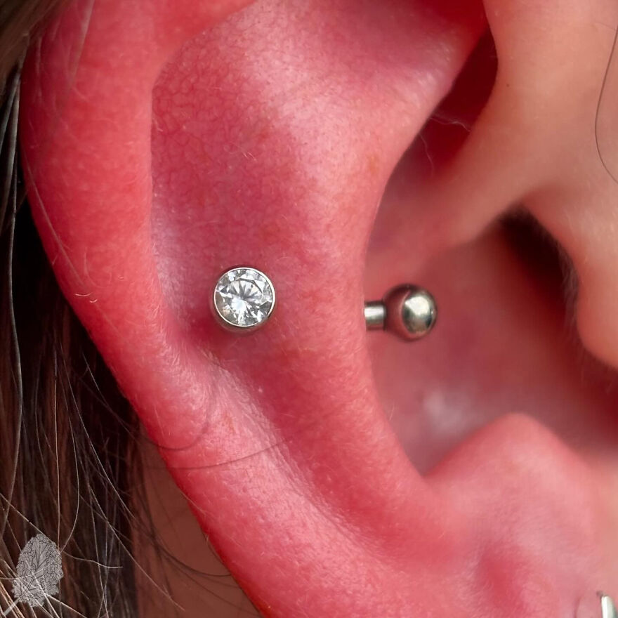 Close-up of an ear with a shiny stud cartilage piercing showcasing one type of ear piercing style.