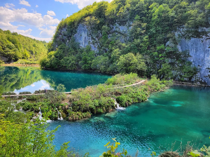 Lush green landscape with clear blue water at one of the best countries to raise a family according to UNICEF index