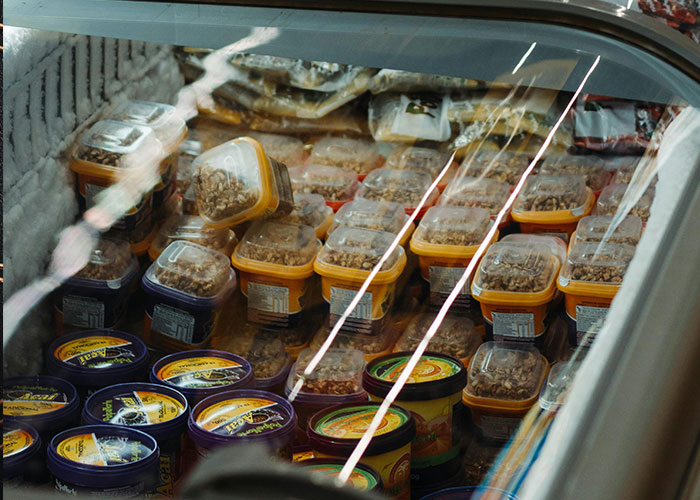 Plastic containers filled with food items arranged neatly inside a refrigerated display, illustrating perfect revenge acts concept.