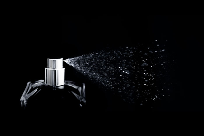 Perfume bottle spraying mist in a dark setting, symbolizing the importance of the phone in cheating revelations.