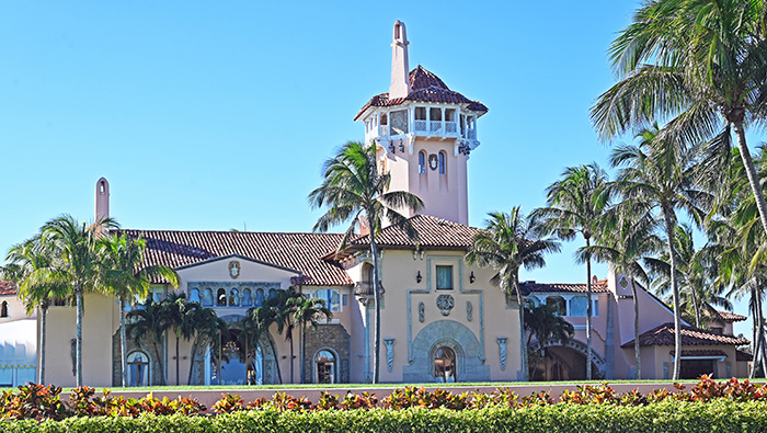 Mar-a-Lago estate exterior with palm trees under clear sky related to Epstein victim Trump claims in new files.