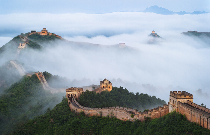 Great Wall of China emerging through fog on a mountain, representing one of the oldest countries in the world landmarks.
