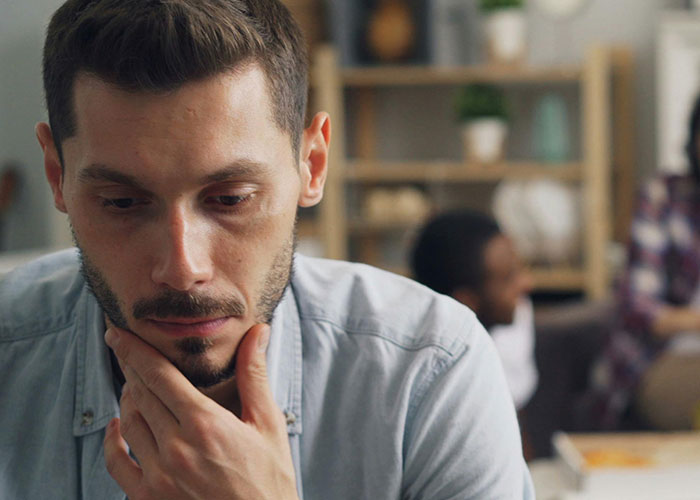 Man deep in thought during a group session, reflecting on experiences related to being neurodivergent.