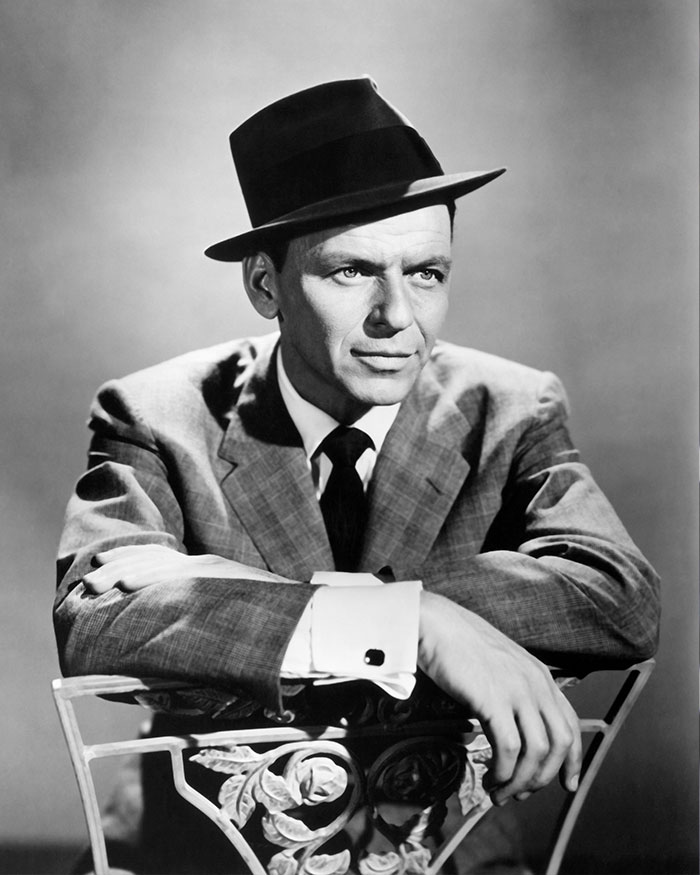 Black and white portrait of a man in a suit and hat, illustrating hidden stories in famous songs for music fans.