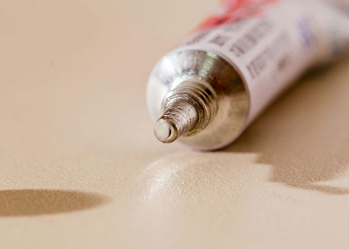 Close-up of a silver tube with a small drop on the tip, illustrating one of the perfect revenge acts never caught.