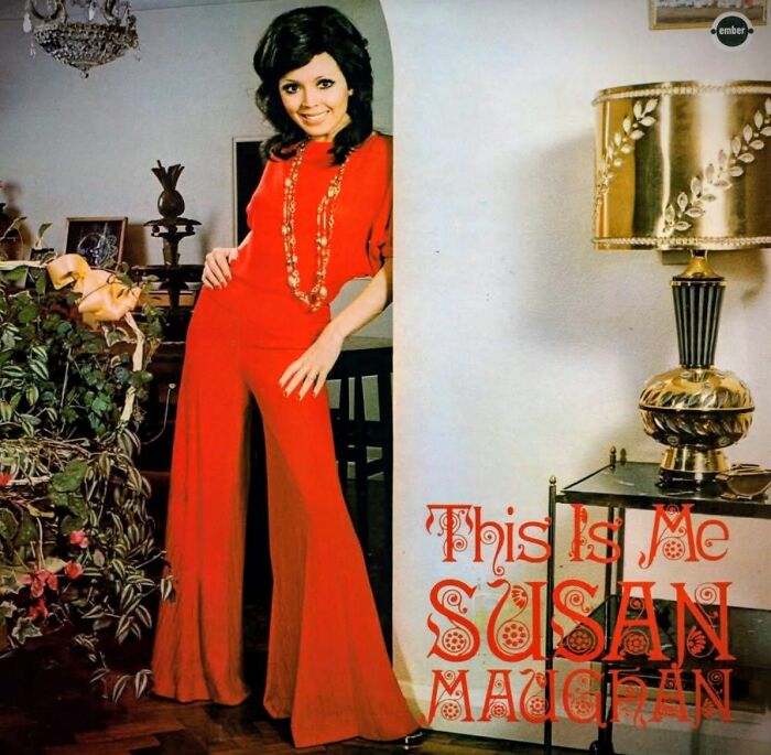 Woman in a red jumpsuit posing indoors next to vintage decor on a hilariously bad album cover design.