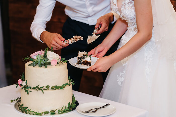 Bride and groom cutting wedding cake together, illustrating one of the fastest times couples said I do and I'm done.