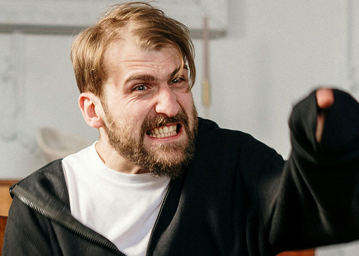 Angry husband throwing a full-blown tantrum indoors, expressing frustration and shouting intensely.