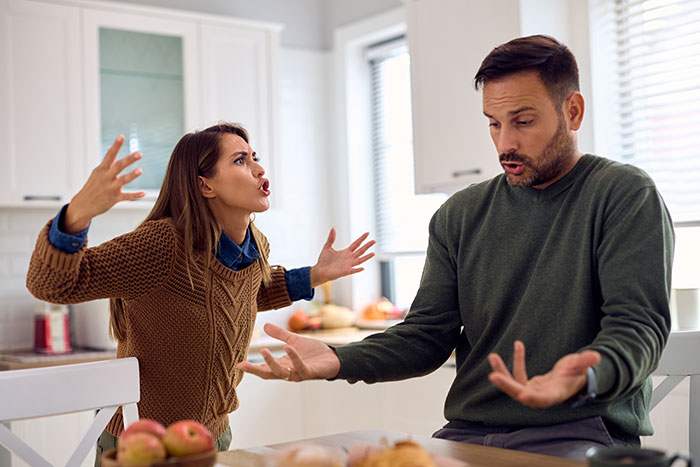 Couple arguing in kitchen after man eats pregnant partner&rsquo;s craving treat, her frustrated expression and his wild excuse.