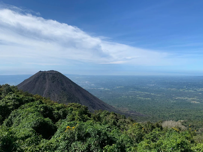 Volcanic cone and green landscape under a blue sky, scenic backdrop for Most Stressful Countries feature image