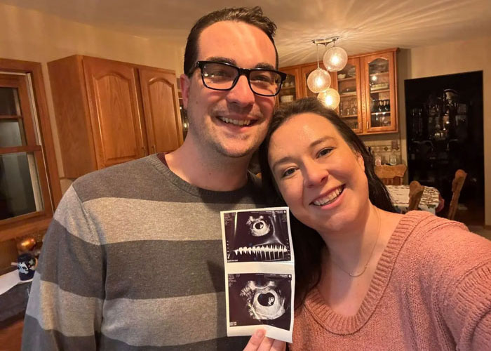 Smiling couple in kitchen holding ultrasound photos and announcing pregnancy, Disney World
