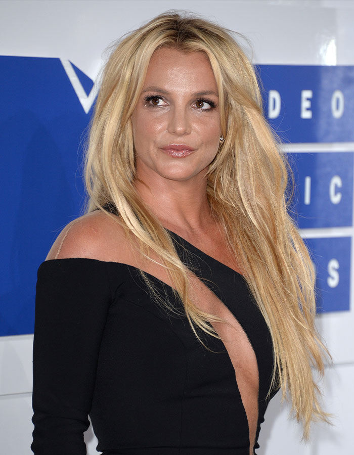 Britney Spears in a black dress at a music event, facing backlash after saying she will never perform in the US again