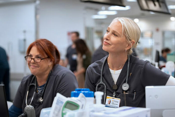 Two nurses in a hospital setting focused on The Pitt Season 2 Episode 1 recap before watching Episode 2.
