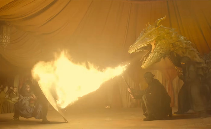 A knight battling a dragon with fire in a dimly lit tent, reflecting fans divided over Rotten Tomatoes rating.