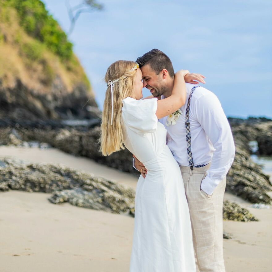 Couple embracing on a beach sharing a joyful moment, illustrating fun questions to ask your partner for connection.