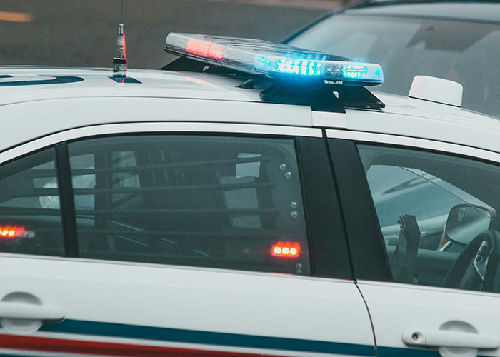 Police car with flashing lights indicating a scene linked to perfect revenge acts that went unnoticed by authorities.