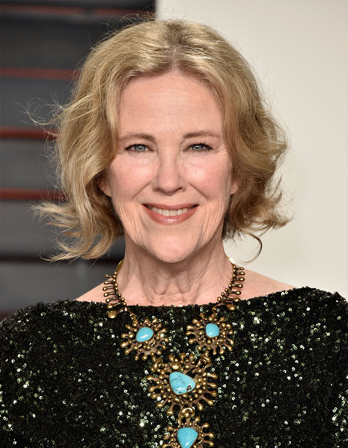 Schitt’s Creek star Catherine O'Hara smiling, wearing a black sequined top and a statement turquoise necklace. Schitt’s Creek star Catherine O'Hara smiling, wearing a black sequined top and a statement turquoise necklace.