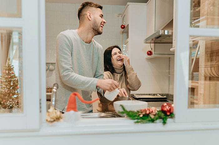 Couple laughing together in kitchen, highlighting karma and affair partner leaving after cheating on husband. Couple laughing together in kitchen, highlighting karma and affair partner leaving after cheating on husband.