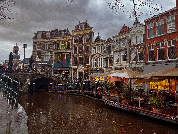 Canal view of historic buildings and cafes in one of the best countries to raise a family, showing urban charm and child-friendly spaces.
