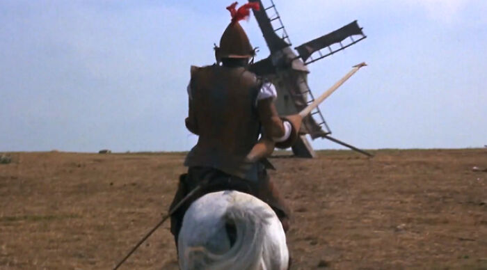 Would You Rather lone knight on horseback charging a windmill in an open field, cinematic scene