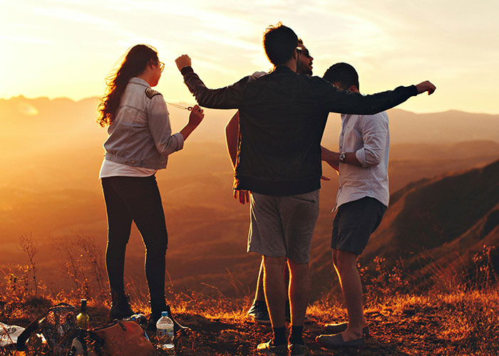 Group of friends enjoying sunset outdoors, illustrating habits neurodivergent people thought were normal in social settings