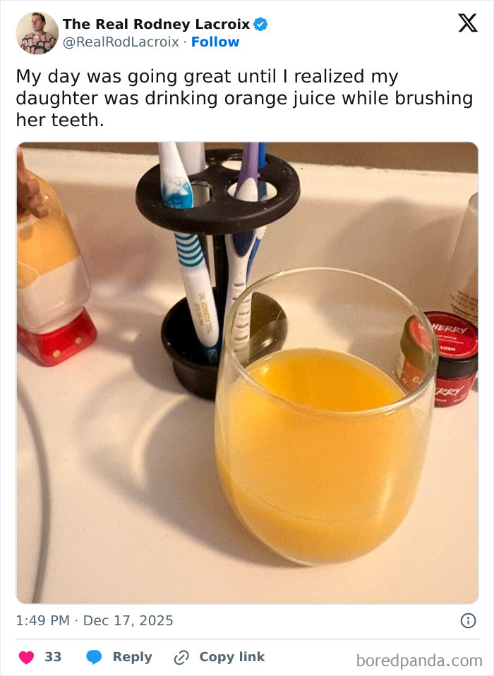 Glass of orange juice on bathroom sink with toothbrushes, illustrating a funny and relatable dad and husband moment.