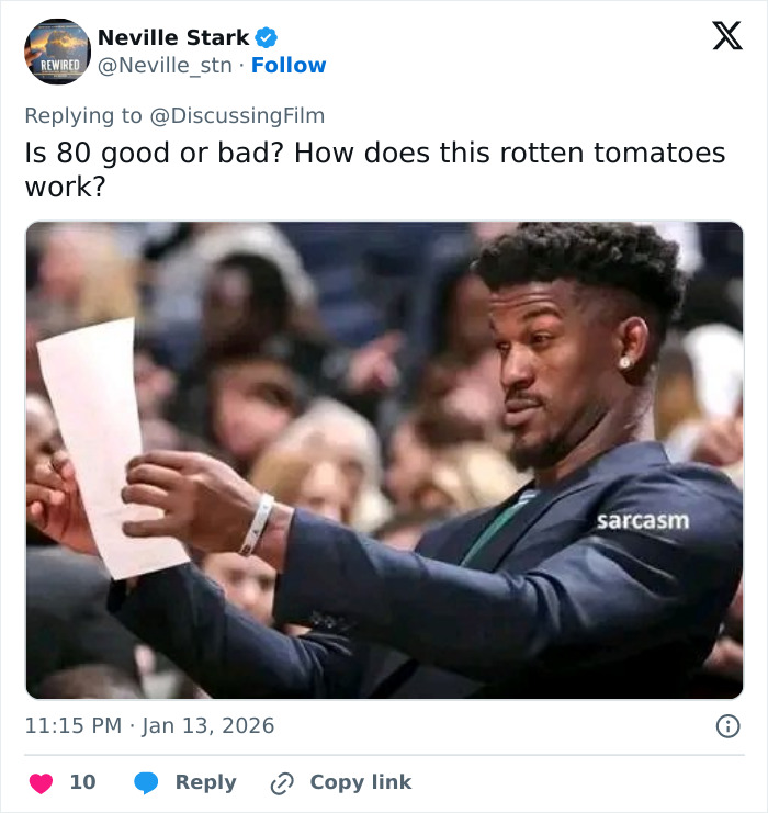 Man in suit holding paper with sarcastic expression, reflecting fans divided over A Knight of the Seven Kingdoms Rotten Tomatoes rating.