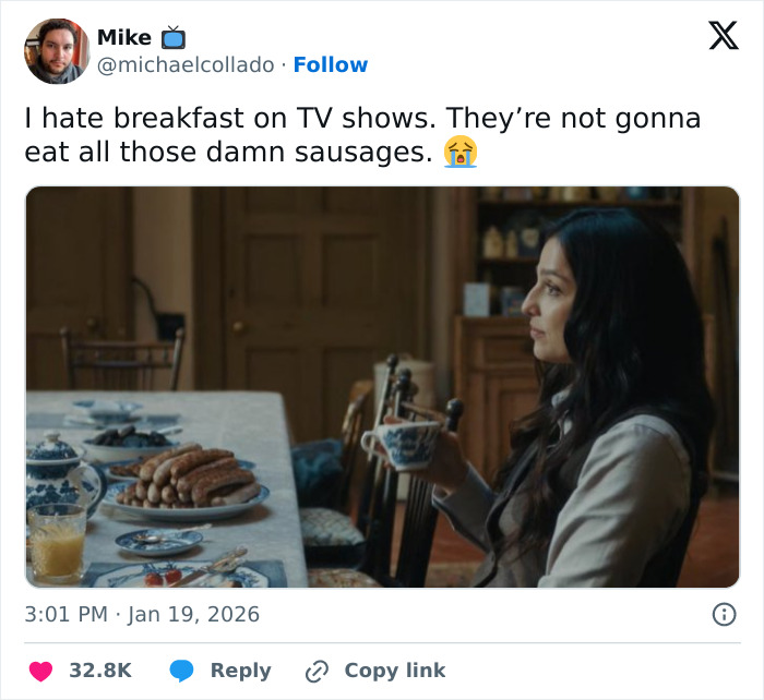Woman sitting at breakfast table with many sausages and holding a cup in a scene from a funny internet tweet in January.