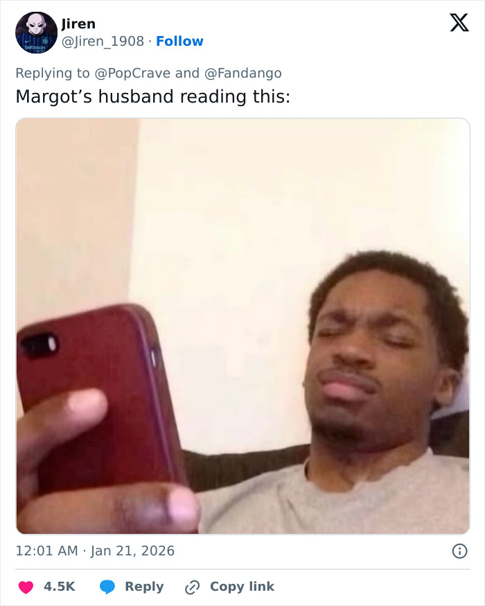 Man looking confused while holding a phone, related to Margot Robbie on-set relationship with Wuthering Heights co-star Jacob Elordi.