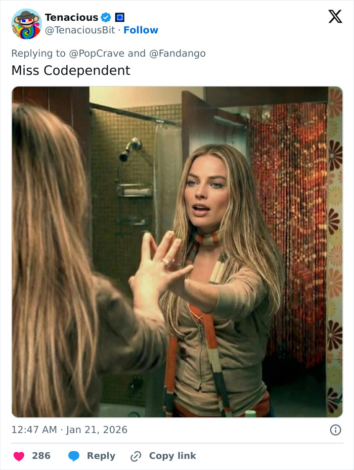 Margot Robbie on set wearing a scarf, looking into a mirror, related to her Wuthering Heights co-star Jacob Elordi rumors.