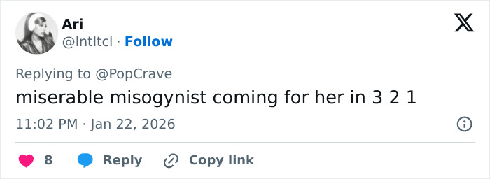 Millie Bobby Brown posing confidently outdoors, showcasing sultry style with windswept hair and casual attire.