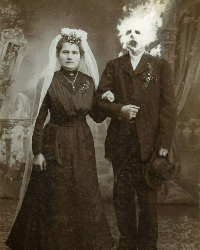 Vintage black and white photo of a bride with a man whose head appears to be engulfed in flames, odd and creepy imagery.