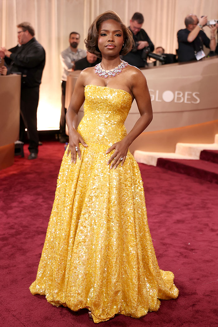 Woman in a sparkling yellow gown and statement necklace at the 2026 Golden Globes showcasing jaw-dropping outfits on the red carpet.