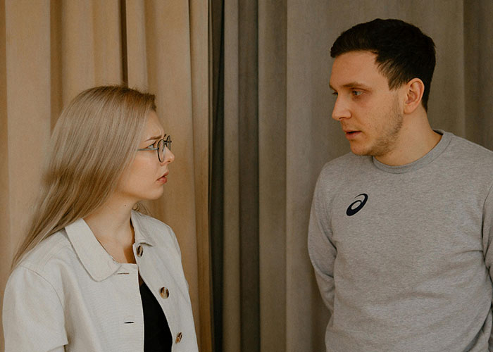 Two people having a serious conversation indoors, illustrating a discussion about neurodivergent experiences and awareness.