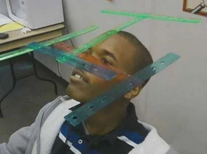 Person balancing colorful plastic rulers on their face, illustrating creative New Year's resolutions ideas.